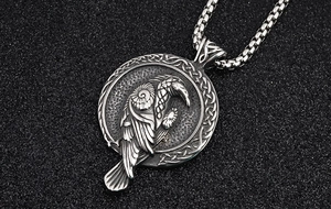 Gros plan du pendentif corbeau viking avec bordure nœud celtique sur chaîne en acier