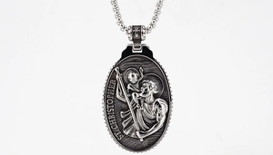 Macro detail of vintage St. Christopher embossed medallion pendant with silver finish