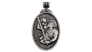 Detailed relief showing St. Christopher engraving on silver vintage oval pendant