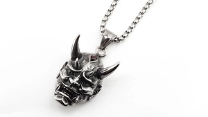 Detail of silver Hannya mask pendant with red garnet stone and vintage steel finish