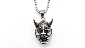 Detailed view of silver Hannya mask pendant with garnet eyes and vintage steel chain