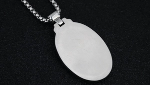 Close-up of vintage silver necklace pendant with brushed metal finish and box chain