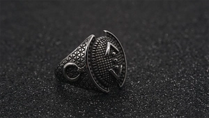 Detail of vintage punk titanium steel ring featuring moon star relief and navy anchor textures