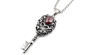 Vue macro du pendentif clé couronne en argent vintage avec grenade rouge et détails de chaîne