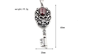 Détail du pendentif clé couronne avec grenat rouge et gravure de fleurs vintage
