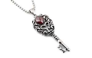 Détail macro du pendentif clé en argent vintage avec grenat serti et chaîne à billes carrées
