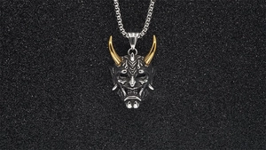 Macro view of Hannya mask pendant with gold horns and vintage metal finish detail