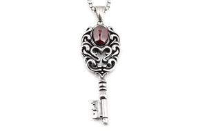 Vue détaillée du pendentif clé en argent rétro avec motifs de cœur et pierre grenat