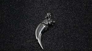 Macro view of polished stainless steel wolf tooth pendant with detailed wolf head engraving
