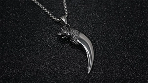 Macro shot of vintage wolf tooth pendant in antique silver finish with detailed carving