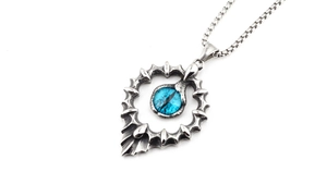 Détail du pendentif œil de tournesol hip hop avec incrustation d'œil de dragon bleu et acier