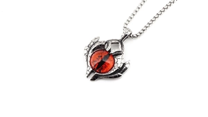 Detailed close-up of retro silver dragon eye pendant with red stone and cracked texture