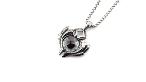 Macro shot of vintage silver-tone demon eye pendant with cracked texture detail