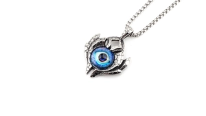 Macro shot of silver gothic devil eye pendant with blue gemstone and claw texture