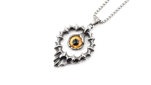 Vue détaillée du pendentif œil de Dieu hip-hop avec œil orange et texture en acier vintage