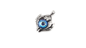 Macro shot of vintage evil eye pendant featuring blue stone and cracked silver finish