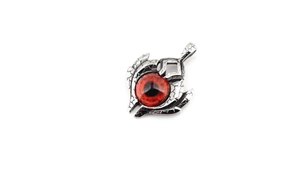 Macro detail of gothic silver metal pendant with a striking red eye gemstone inlay
