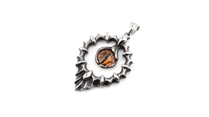 Gros plan sur un pendentif gothique œil en titane argenté avec écailles et pierre orange
