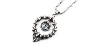 Gros plan du pendentif cœur gothique avec œil bleu détaillé et chaîne argentée