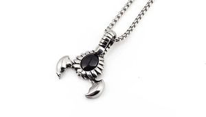 Detail of scorpion pendant with black gemstone inlay and box chain in gothic punk style