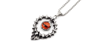 Détail du pendentif œil de dragon vintage en argent avec gemme orange sur chaîne