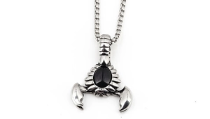 Detailed view of antique silver scorpion pendant with a black gemstone on a square box chain