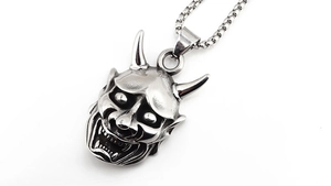 Detailed view of retro silver Hannya mask pendant with intricate facial carvings
