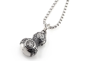 Macro shot of retro stainless steel gourd pendant featuring Fu and Shou carvings on box chain