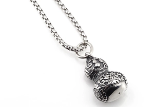 Detailed macro view of vintage stainless steel gourd pendant with lotus engravings