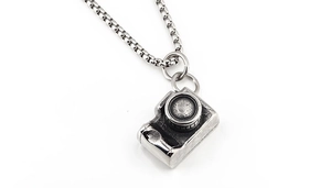 Detail of vintage SLR camera pendant with textured alloy surface on a chain