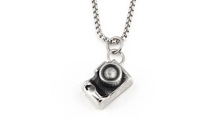Close-up of retro silver camera pendant with box chain showing vintage details