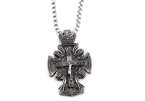Gros plan d'un pendentif crucifix en argent vintage avec détails baroques et chaîne box