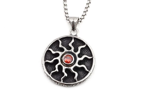 Détail du pendentif soleil vintage en acier titane avec une pierre rouge