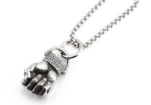 Detailed view of a vintage silver fist pendant with textured wrist on a thick box chain