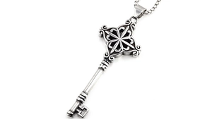 Détail du pendentif clé vintage avec motif étoilé et chaîne à mailles carrées