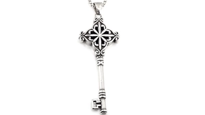 Détail du pendentif clé vintage avec croix et motifs volutes sur chaîne argentée
