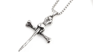 Macro shot of gothic punk cross pendant featuring skeletal bones and nail head textures