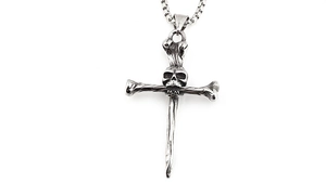 Macro detail of vintage punk skull and bone cross pendant with a box chain necklace