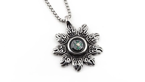 Macro view of compass sun pendant with flame motif and functional miniature compass