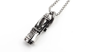 Detail macro of vintage silver pendant with carved bamboo leaves and a coiled snake design