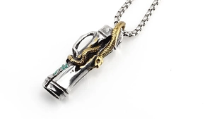Close-up of vintage punk cylinder pendant with golden 3D snake and green enamel detail