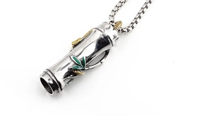 Detail of vintage bamboo pendant with golden snake and green enamel leaves