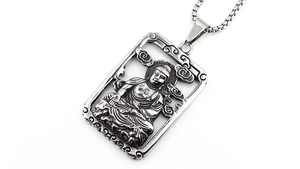 Makroaufnahme des Vintage-Buddha-Anhängers aus Edelstahl mit Wolkengravuren am Rand