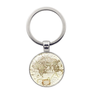 Macro detail of silver metal keychain featuring a vintage world map under glass cabochon