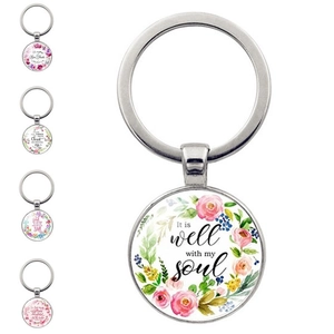 Detail view of 5-piece silver keychain set with floral patterns and inspirational quotes