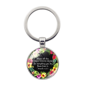 Detail of round metal keychain with Bible verse guard your heart and floral pattern