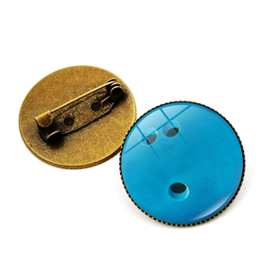Detailed macro view showing both sides of a vintage bronze bowling pin lapel badge