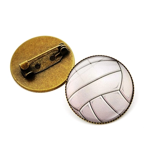 Detail view of round volleyball glass brooch with bronze metal pin and safety clasp back