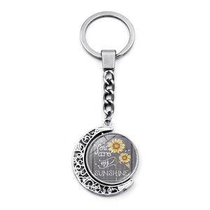 Close-up of rotating sun and moon keychain with You Are My Sunshine engraving