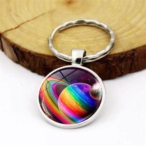 Creative galaxy planet keychain with colorful nebula pendant on wood slice background